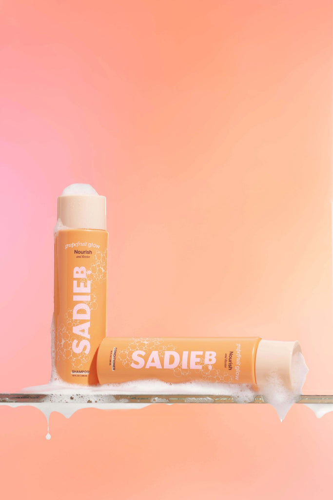SADIEB hair product bottle on a gradient pink and orange background
